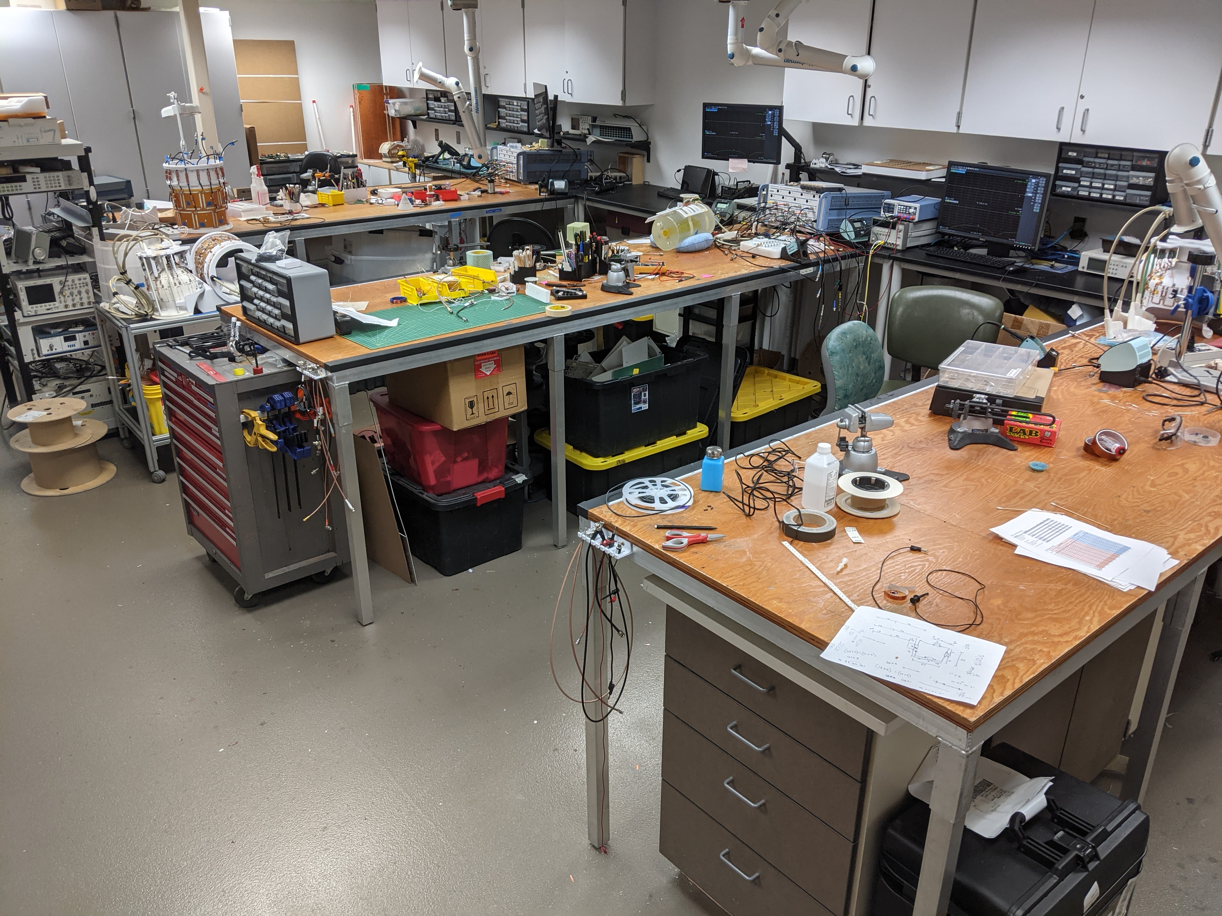 Three electronics benches with tools, projects, and RF equipment